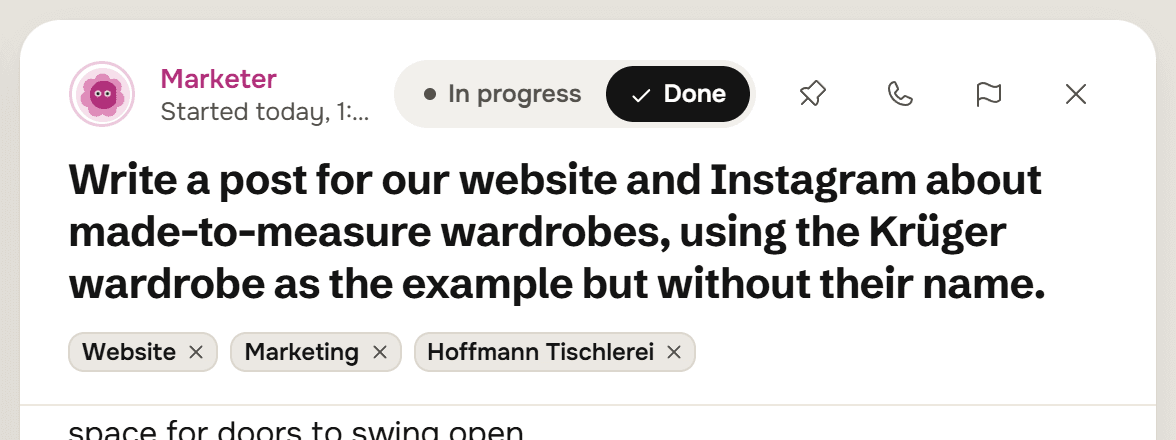 The head of an open thread from the Marketer: In progress and Done, a pin, a phone and a flag, the request Write a post for our website and Instagram about made-to-measure wardrobes, using the Krüger wardrobe as the example but without their name, and the tags Website, Marketing and Hoffmann Tischlerei.